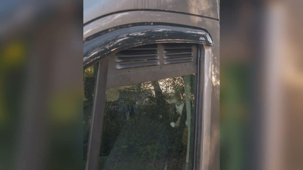 Photo is of a metal window vent that slides into the driver side cab window of a Ford Transit van