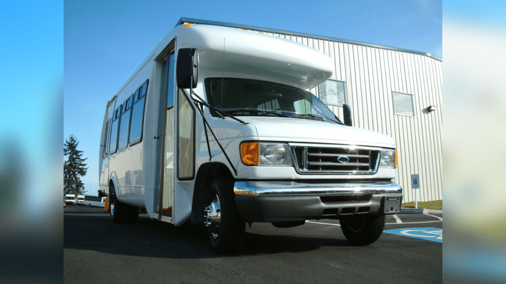 White passenger shuttle bus parked in a parking lot